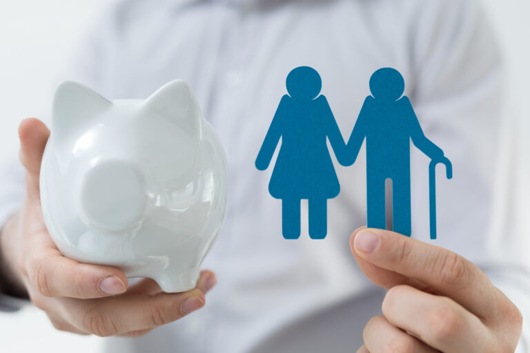 Person holding a white piggy bank next to blue family icons, symbolizing family savings or insurance.